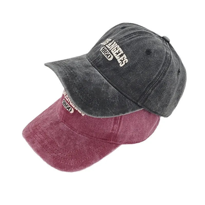 Retro peaked cap with distressed letter embroidery and adjustable sizing in conical crown design