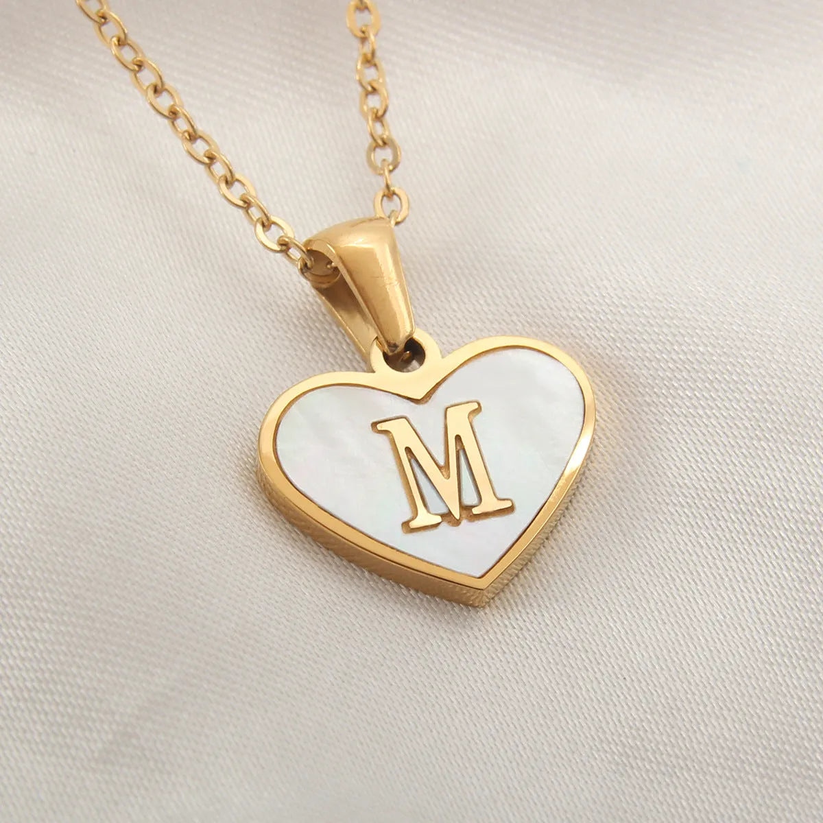 Gold plated heart-shaped personalised necklace with white shell charm on an adjustable chain.