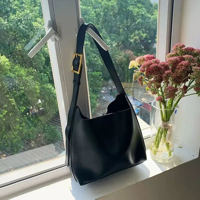 Two women's soft PU shoulder bags with swing threads, one black and one brown, showing structured design.