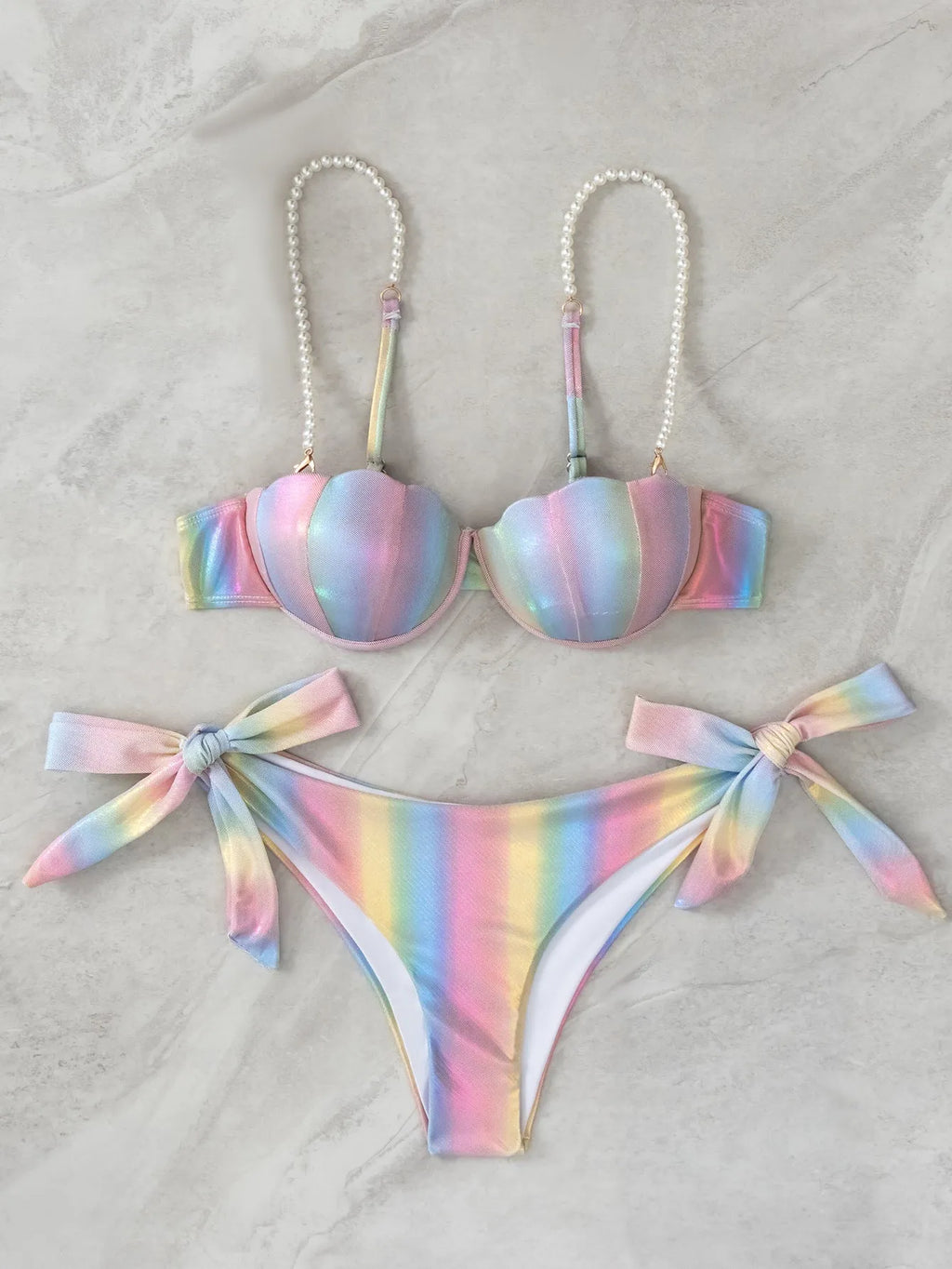 Women's shell rainbow patterned bikini swimsuit with a split tied front, on a mannequin.