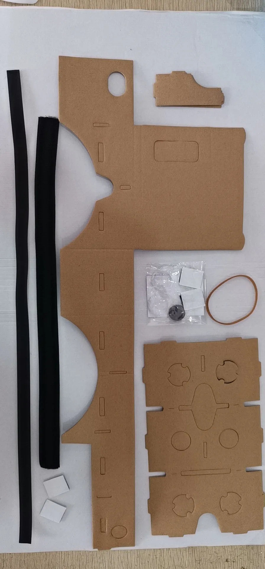 Pink and white cardboard VR glasses for smartphones with head strap and 3D lenses.