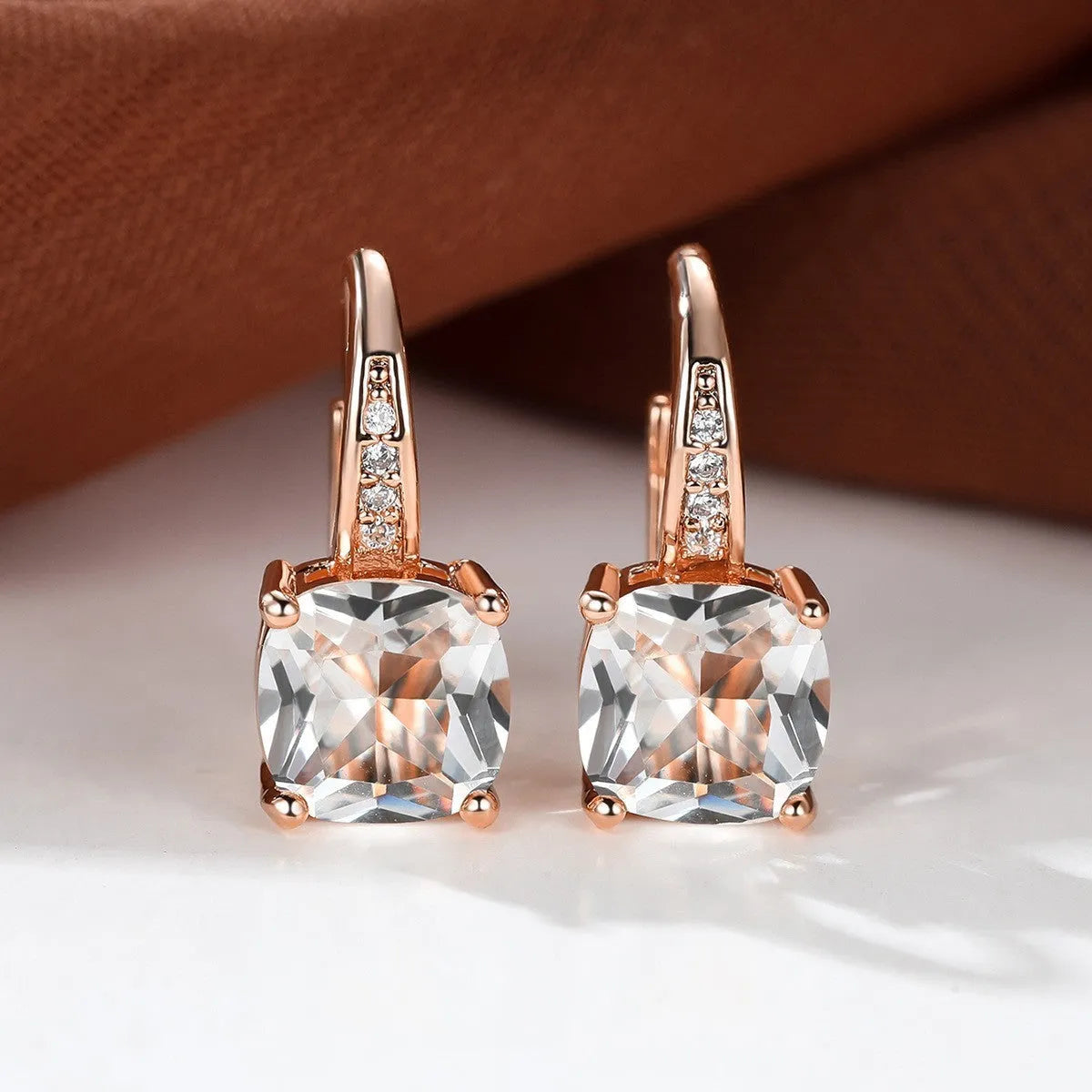 Square geometric ear hook earrings with zircon stones in an electroplated copper setting.