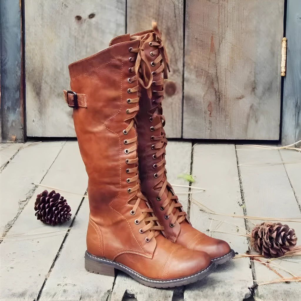 Black chunky heel high leg boots with a round toe and short stout heel on a plain background.