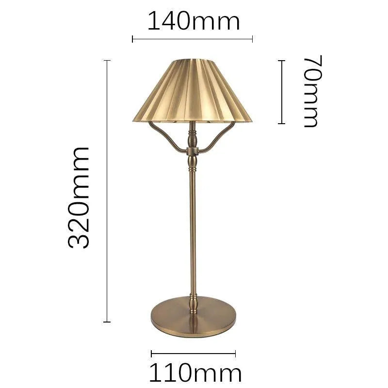 Gold alloy desk lamp with a fabric shade on a wooden table
