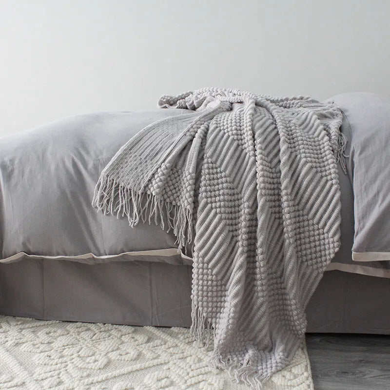 Small light grey polyester nap blanket folded, showing its 127cm by 170cm size.