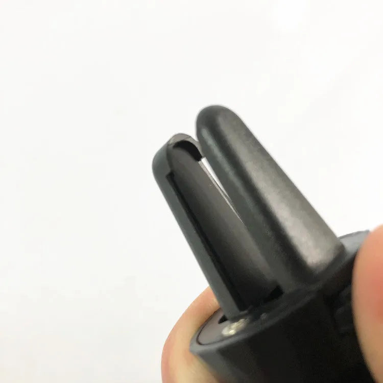 Glossy black car phone holder mounted on vehicle air vent holding smartphone