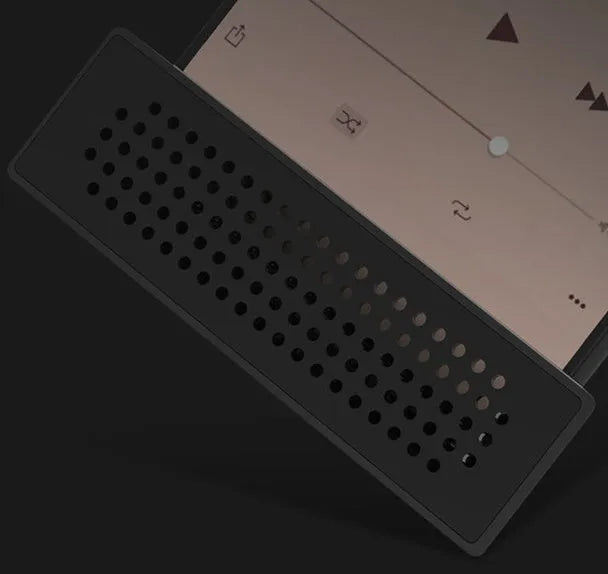 A portable black ABS plastic phone amplifier holder on a desktop, showing a mobile phone inserted for sound amplification.