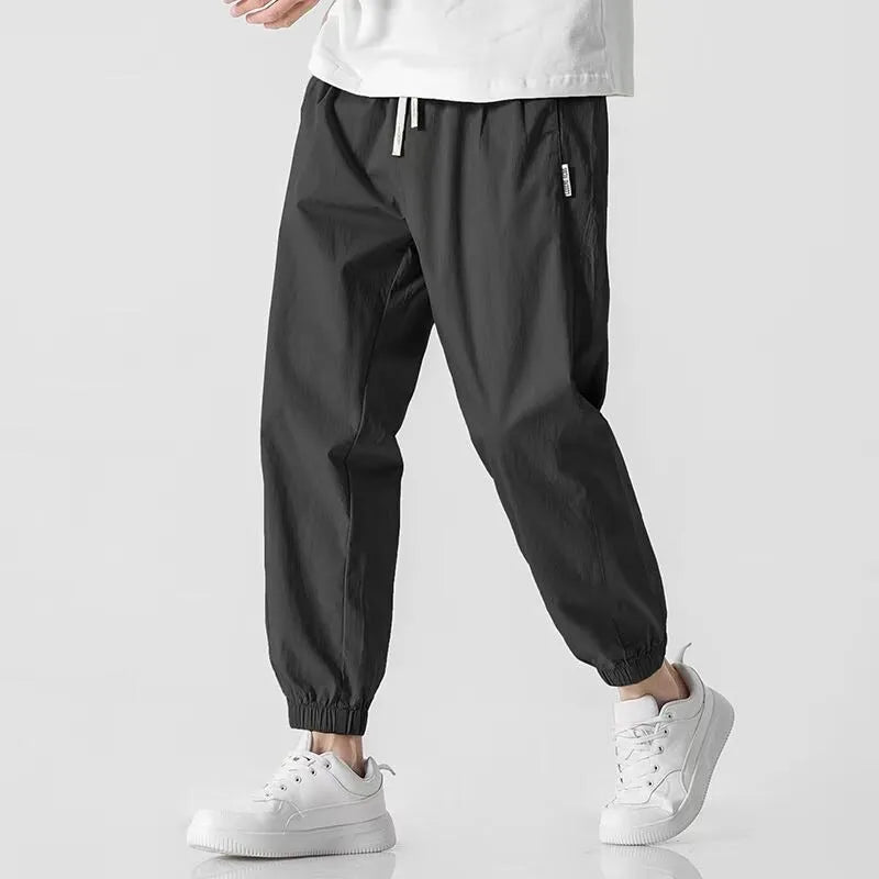 Men's fashion loose cuffed cargo pants in black, made from polyester, available in sizes S to 3XL.