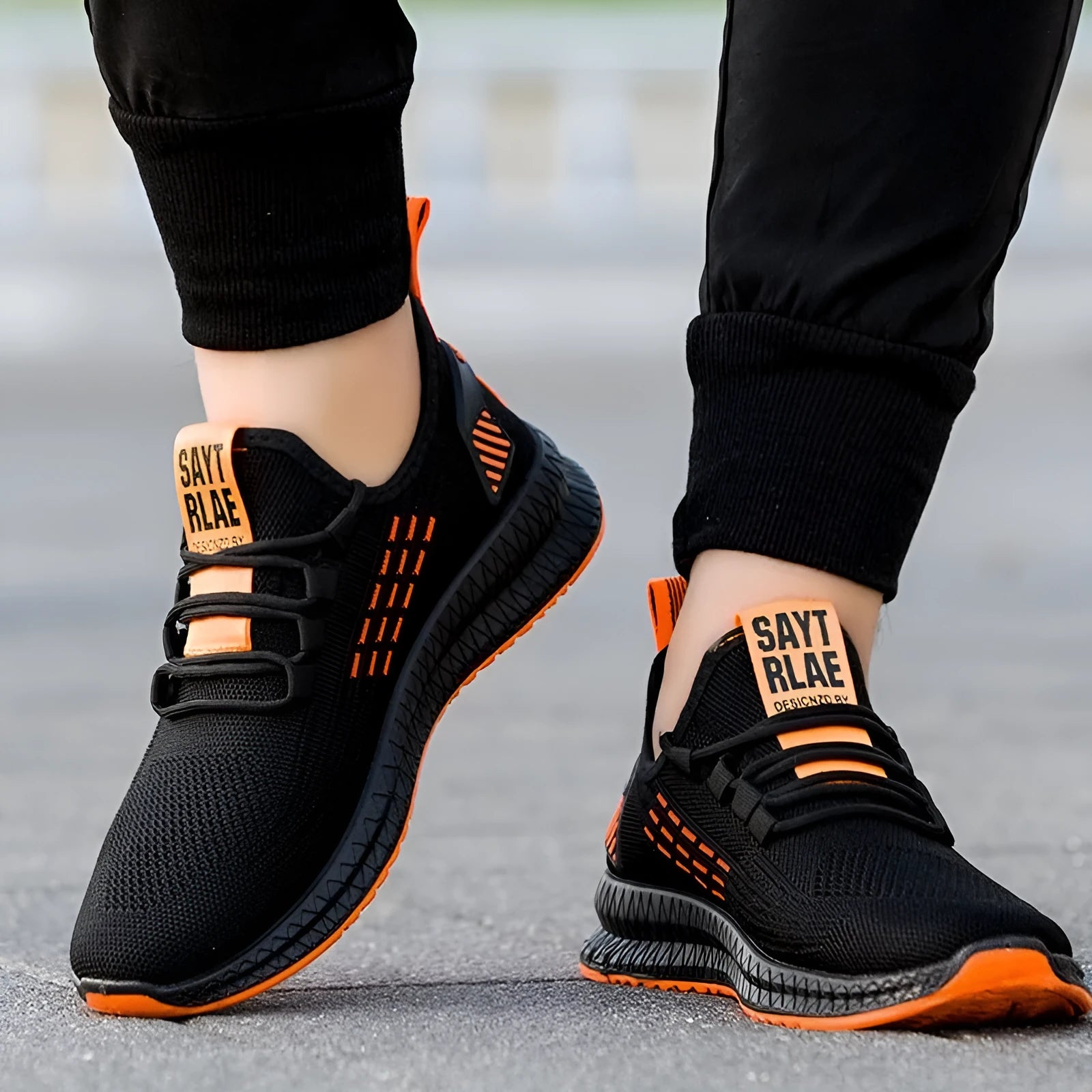 Men's black casual trainers with Flying Weave upper and cross strap detail on low-top sports shoes