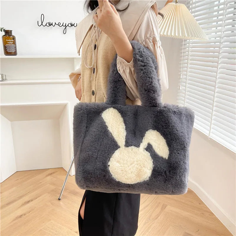 Soft plush shoulder bag with cartoon rabbit ears in one of six solid colours.