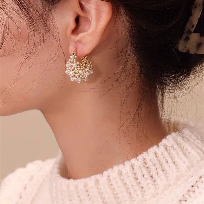 Gold-coloured copper flower basket earrings with rice-shaped bead decoration and pearl inlay detailing