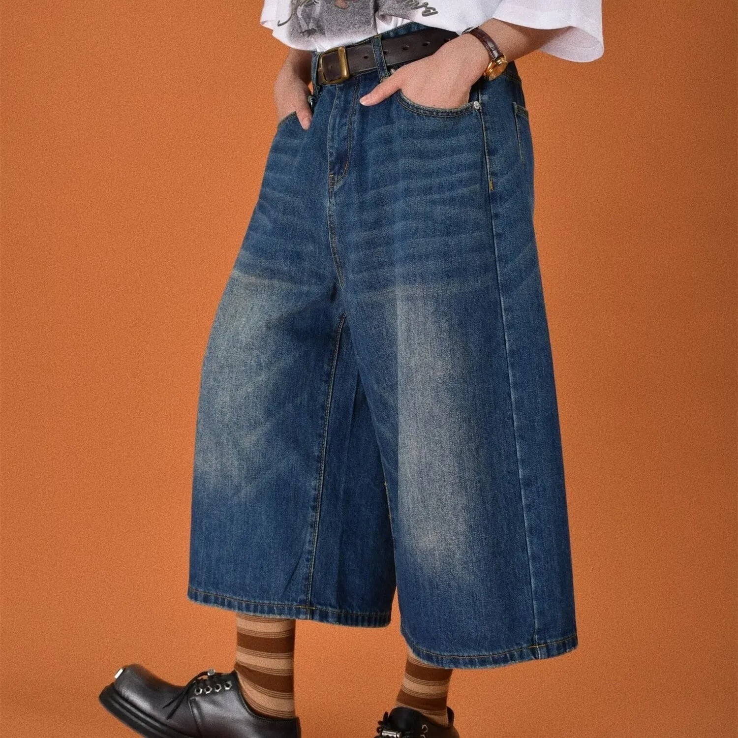 Man wearing blue loose straight-leg denim shorts for summer.