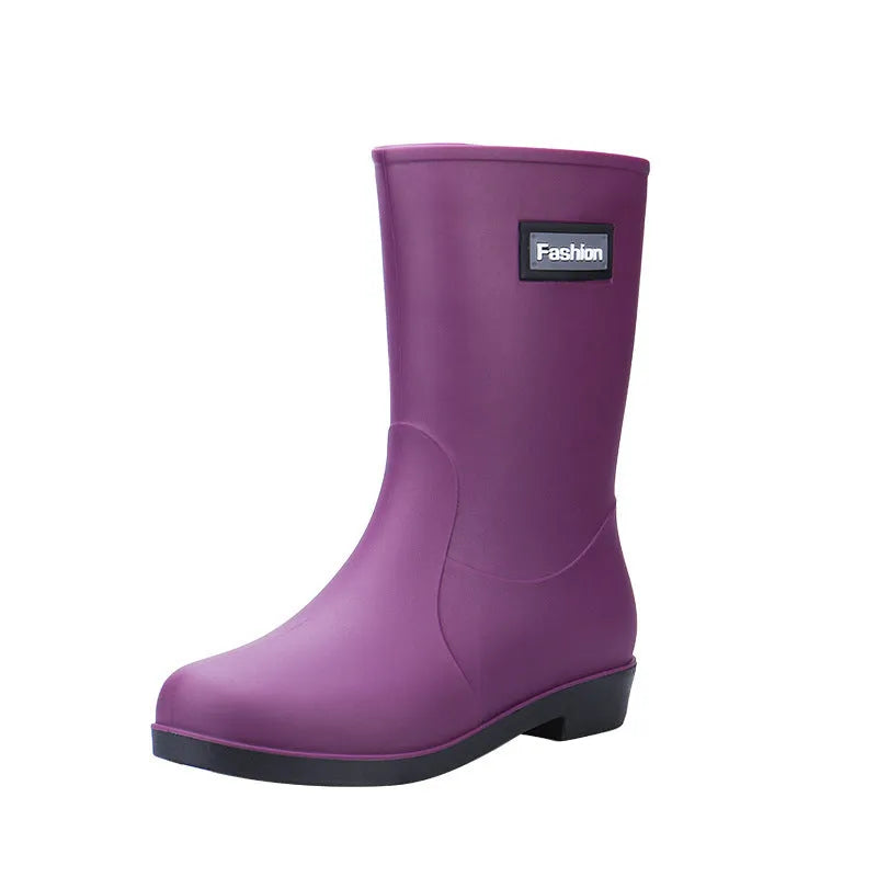 Women's mid-calf PVC rain boot in black on a wet surface.