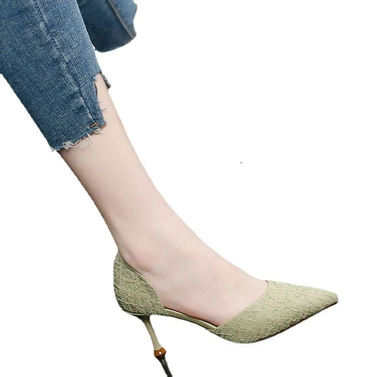 Women's black pointed toe stiletto sandals with a high heel on a plain background.