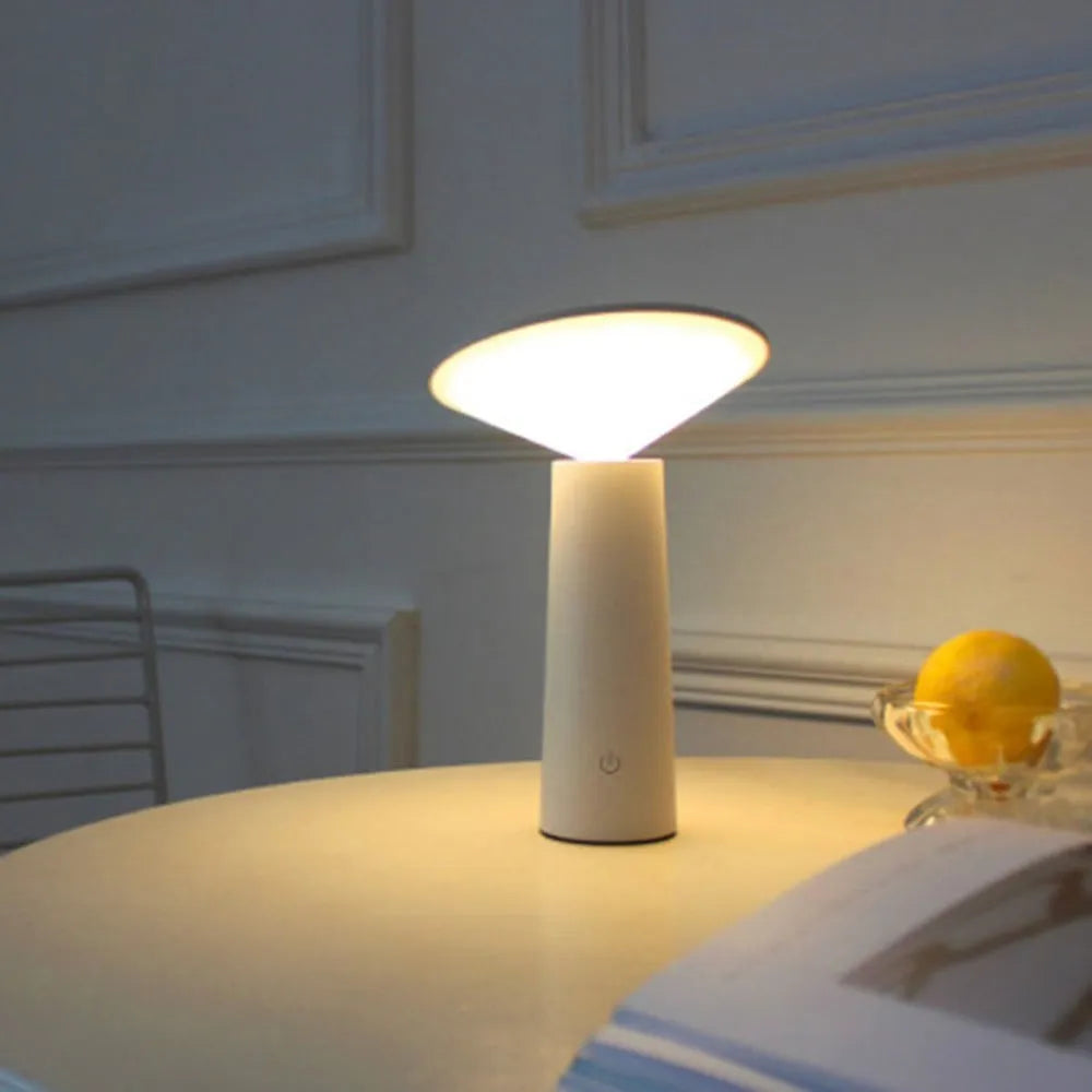 Black USB rechargeable desk lamp with touch sensor and adjustable lamp head on a wooden table.