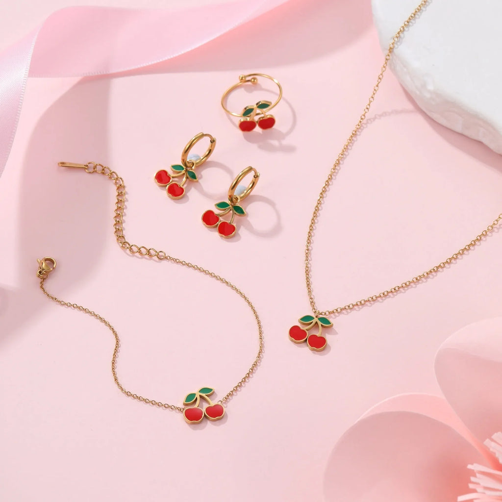 Cherry jewellery set showing necklace, bracelet, earrings and ring with geometric fruit designs on stainless steel chains