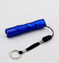 Small black aluminium LED mini flashlight shown next to a AA battery for scale.