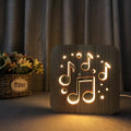 Square wooden LED atmosphere lamp with warm white light and USB cable on a desk