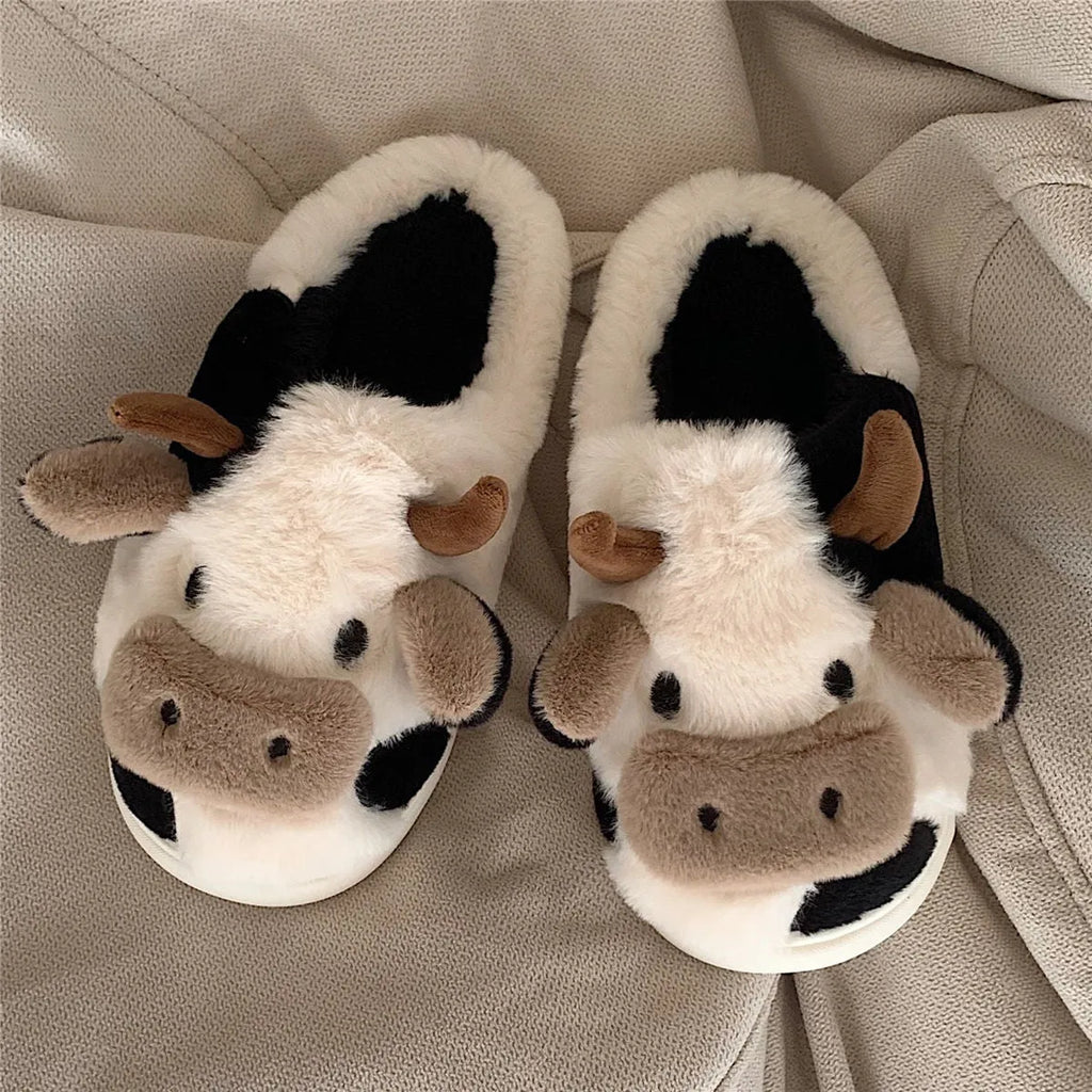 White plush cow slippers for women with a non-slip textured sole.