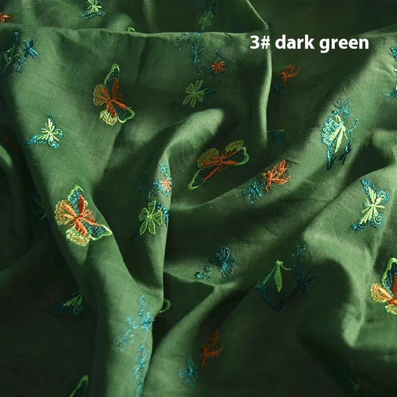 Roll of beige, grass green and dark green 100% ramie fabric for Hanfu sewing and embroidery, showing texture.