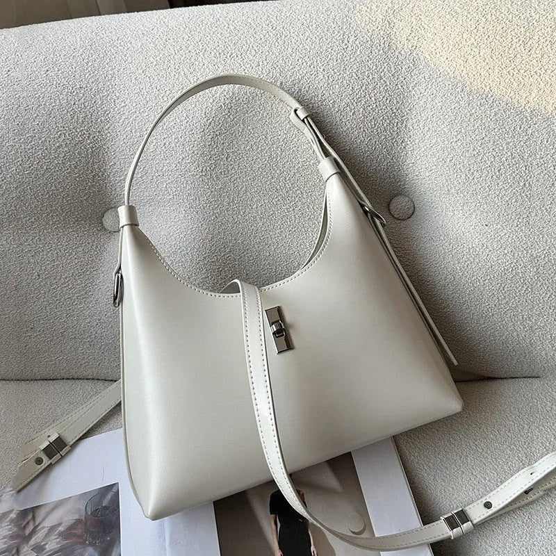 A soft genuine leather dumpling-shaped crossbody shoulder bag in a street style, shown with internal phone pocket.