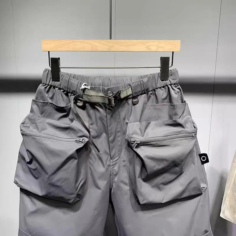 Men's black loose-fit cargo work shorts on a mannequin, showing multiple pockets and above-knee length.