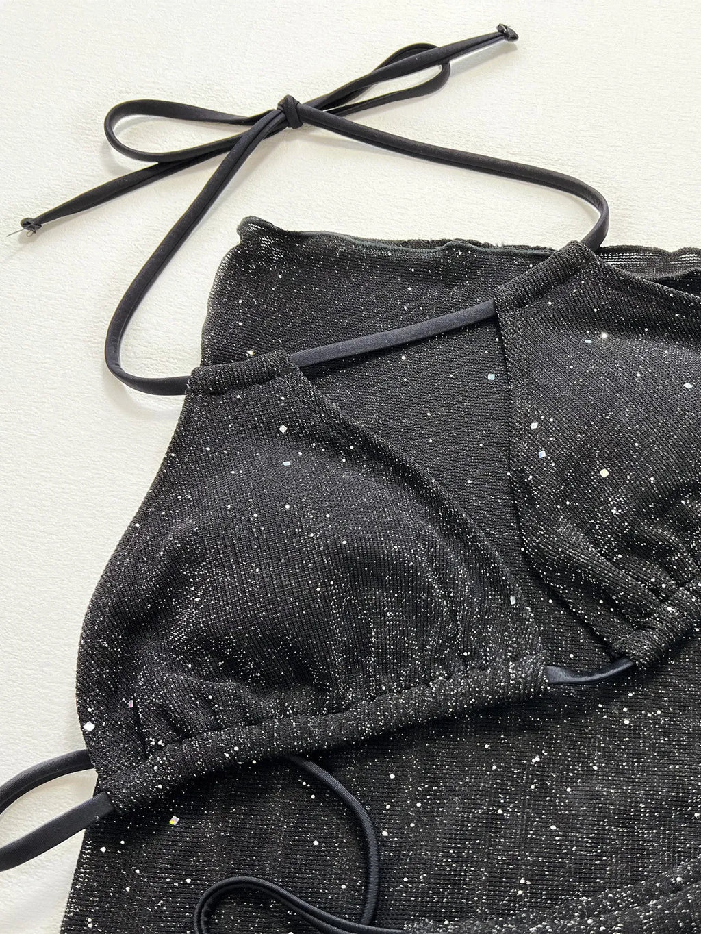 Black women's three-piece bikini swimsuit set with top and shorts.