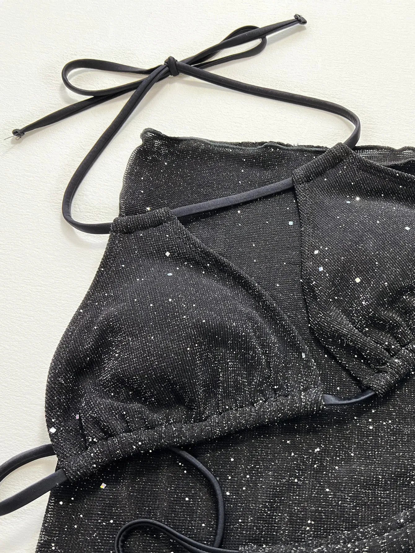 Black women's three-piece bikini swimsuit set with top and shorts.