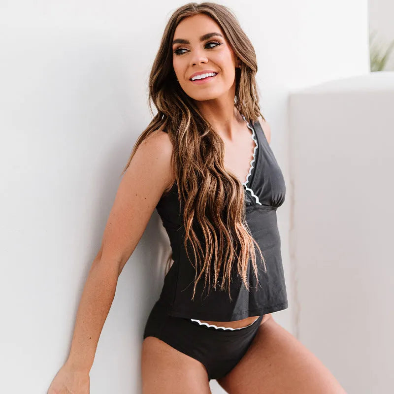 Black one-piece sleeveless swimsuit for women on a mannequin, showing the solid colour and split design.