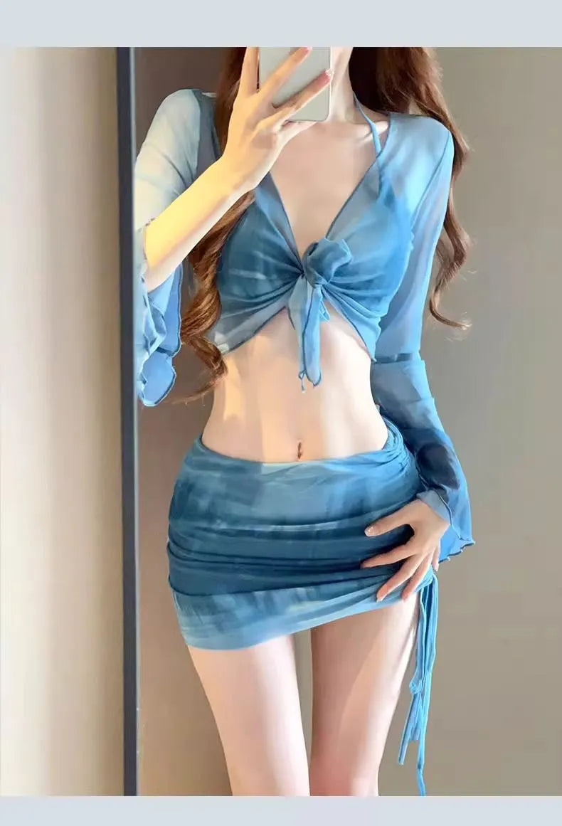 Blue four-piece women's bikini swimsuit set showing shirt, bra, high-waisted briefs, and skirt laid flat.