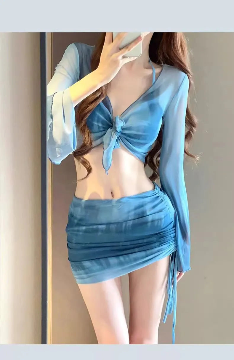 Blue four-piece women's bikini swimsuit set showing shirt, bra, high-waisted briefs, and skirt laid flat.