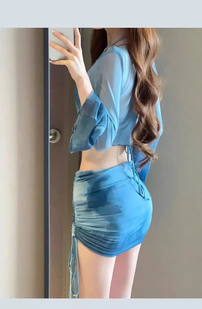 Blue four-piece women's bikini swimsuit set showing shirt, bra, high-waisted briefs, and skirt laid flat.