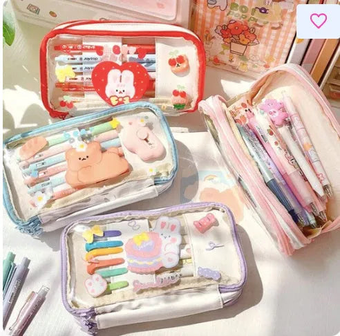 Transparent pink heart-shaped pen case with a cartoon cake and rabbit design, shown open.