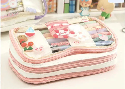 Transparent pink heart-shaped pen case with a cartoon cake and rabbit design, shown open.