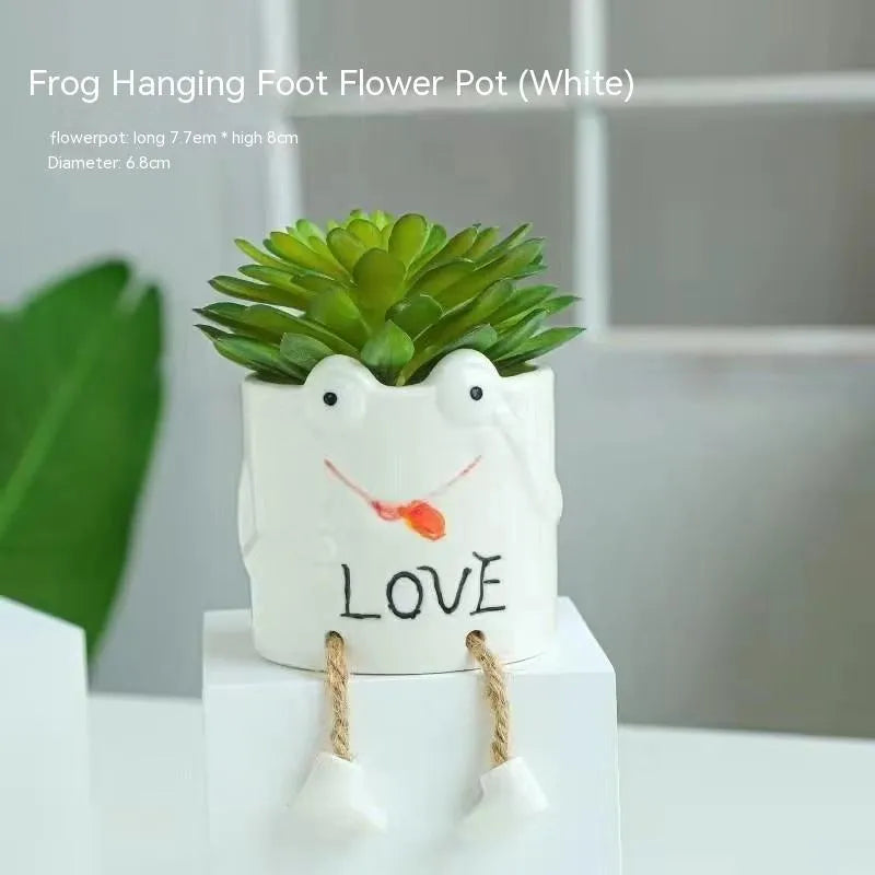 Cartoon style ceramic hanging foot flowerpot for succulent plants on a desktop.