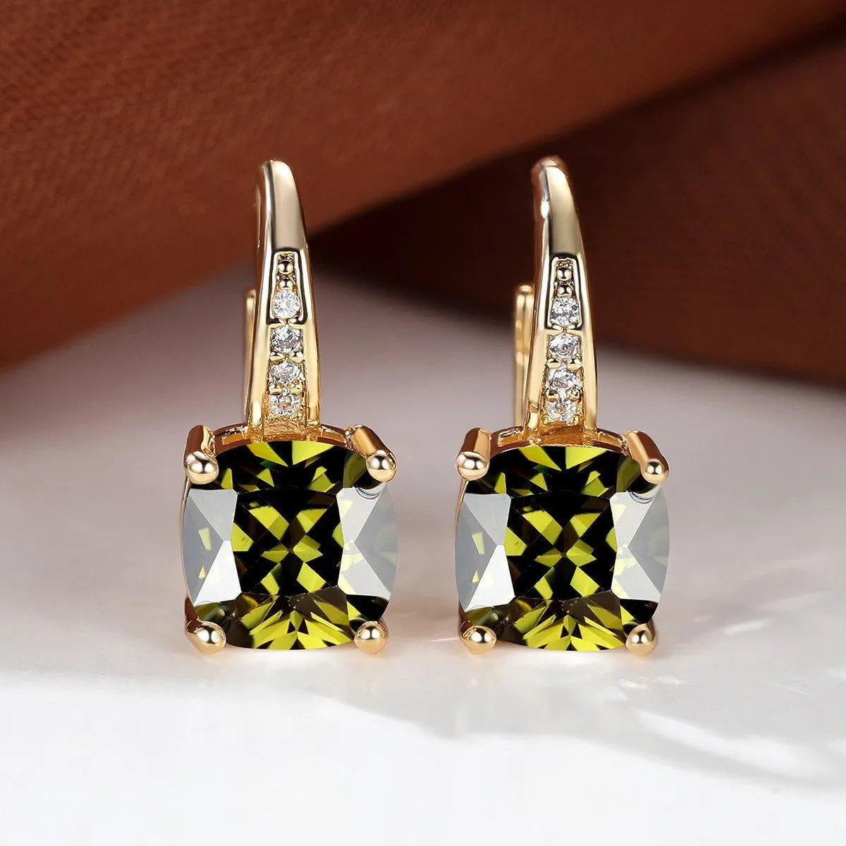 Square geometric ear hook earrings with zircon stones in an electroplated copper setting.