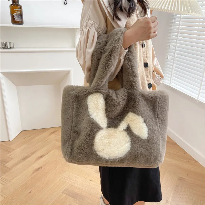 Soft plush shoulder bag with cartoon rabbit ears in one of six solid colours.