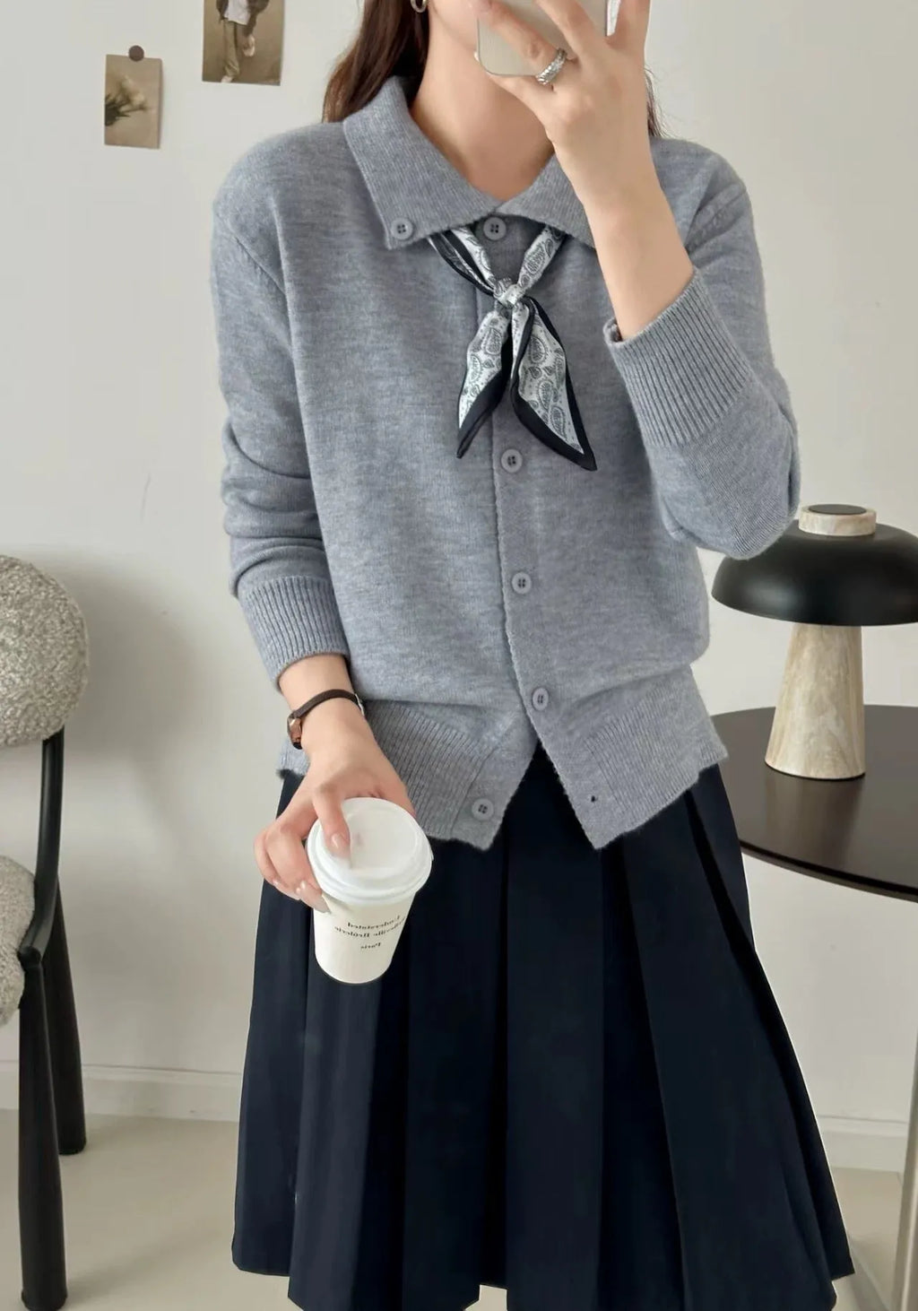 Beige cardigan sweater with a built-in lapel scarf and long sleeves laid flat