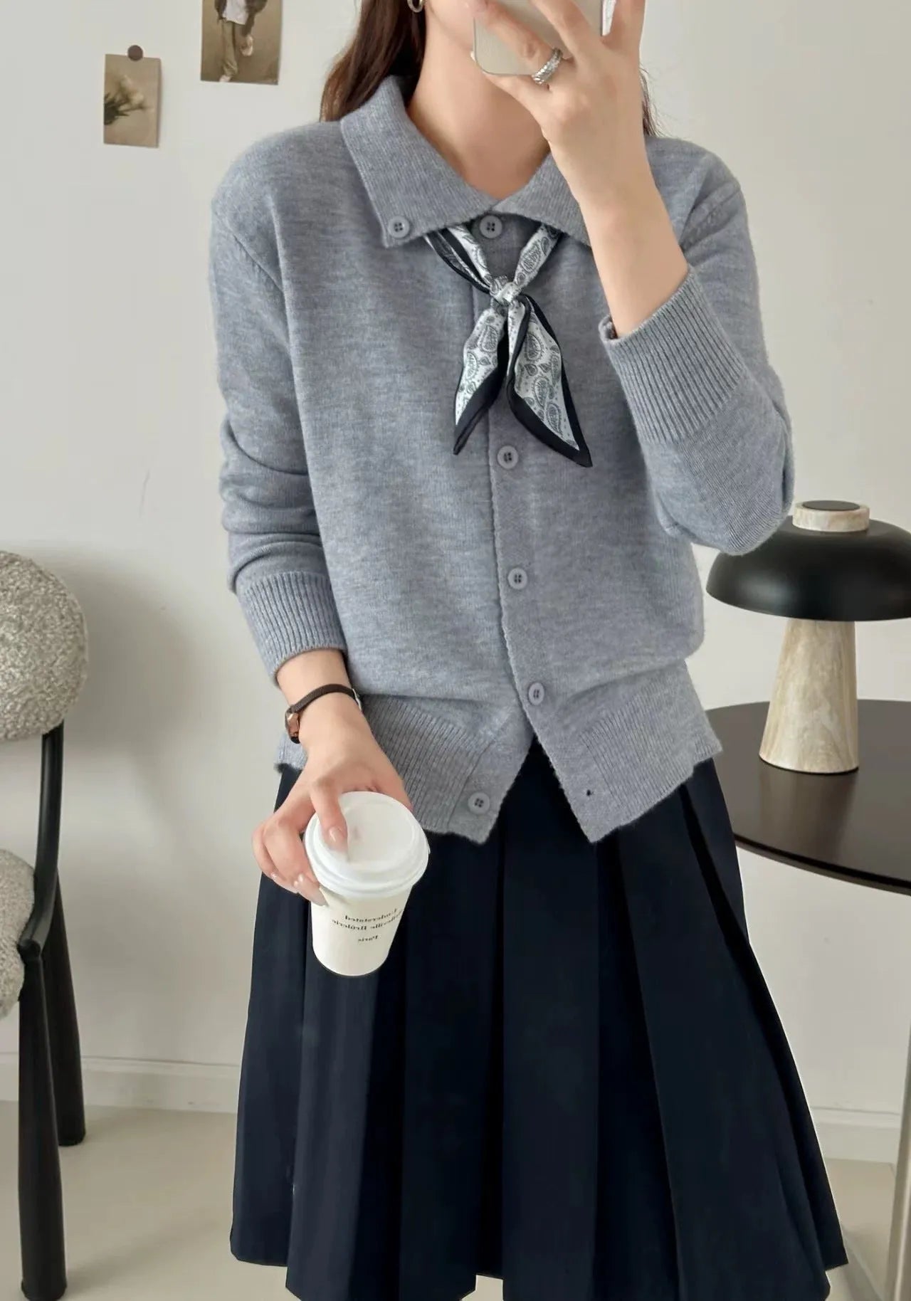 Beige cardigan sweater with a built-in lapel scarf and long sleeves laid flat