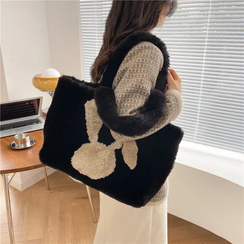 Soft plush shoulder bag with cartoon rabbit ears in one of six solid colours.