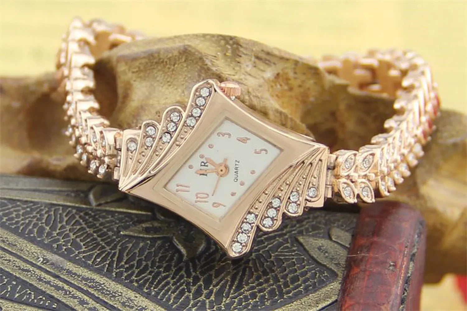 Stone paved wheat shaped metal wristwatch for women in rose golden colour with 2.5cm dial and 19cm band