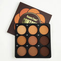 Open dark matte eyeshadow palette showing nine dark coloured pans with a repair disk.