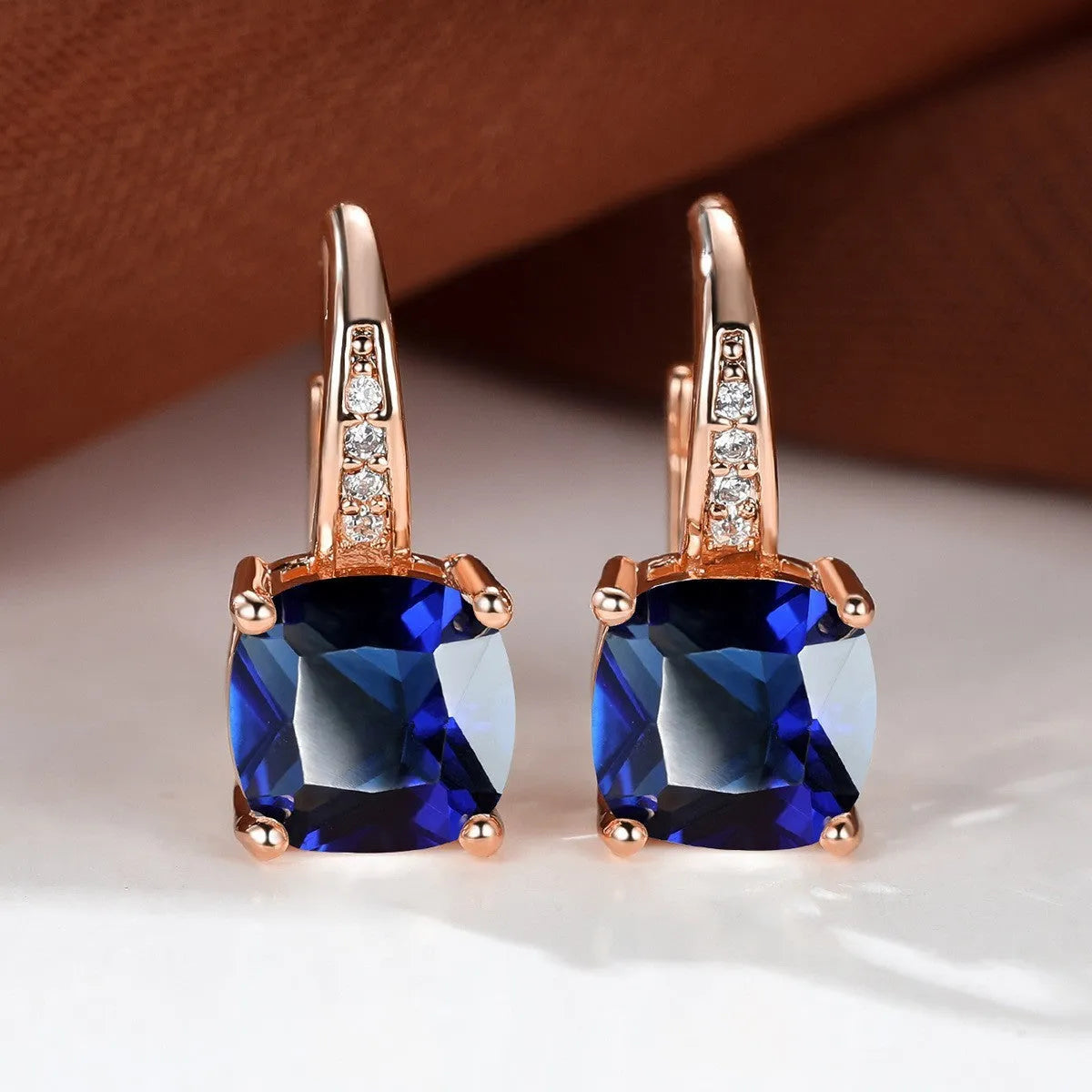 Square geometric ear hook earrings with zircon stones in an electroplated copper setting.