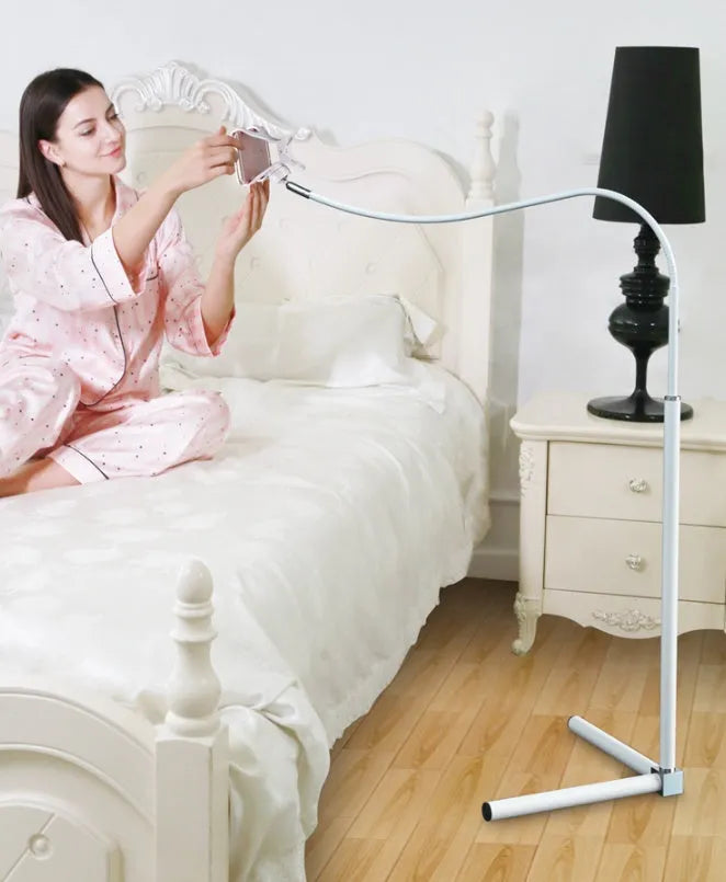 Black bedside mobile phone holder with universal clip and adjustable overhead support shelf mounted on bed frame