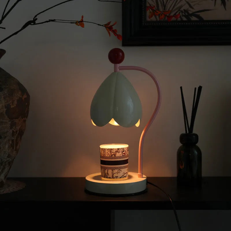 Linglan ancient style melting wax fragrance lamp on a desk, available in cream white or dark green.