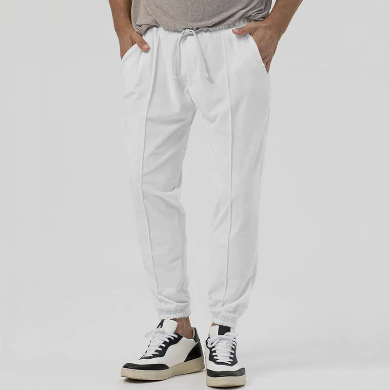 Men's grey casual track sweatpants with loose tapered cut and straight leg design, elastic waistband