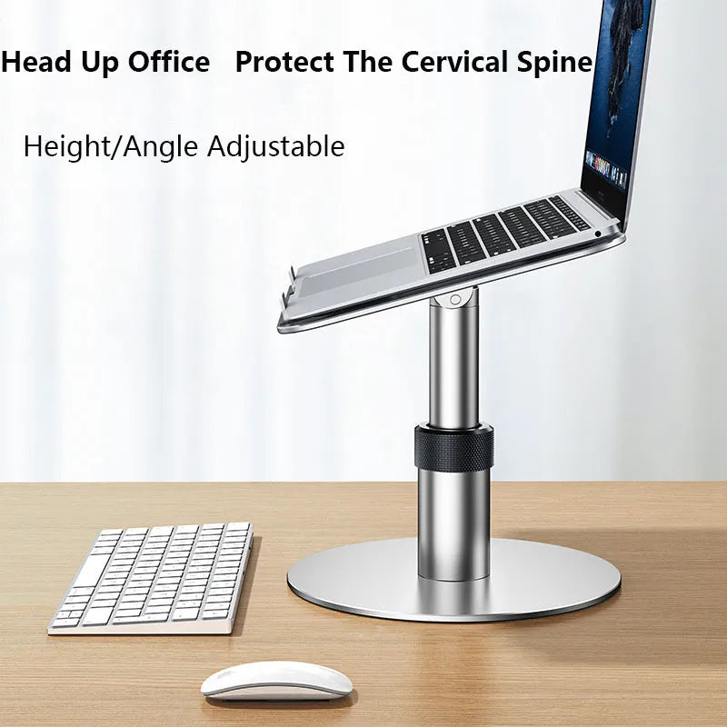 Silver adjustable aluminum laptop stand with non-slip pads on a desk next to a laptop.