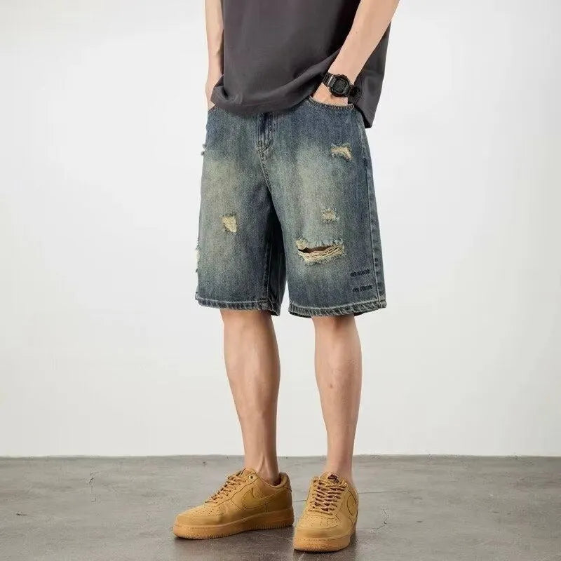 Blue distressed retro denim shorts for men on a white background