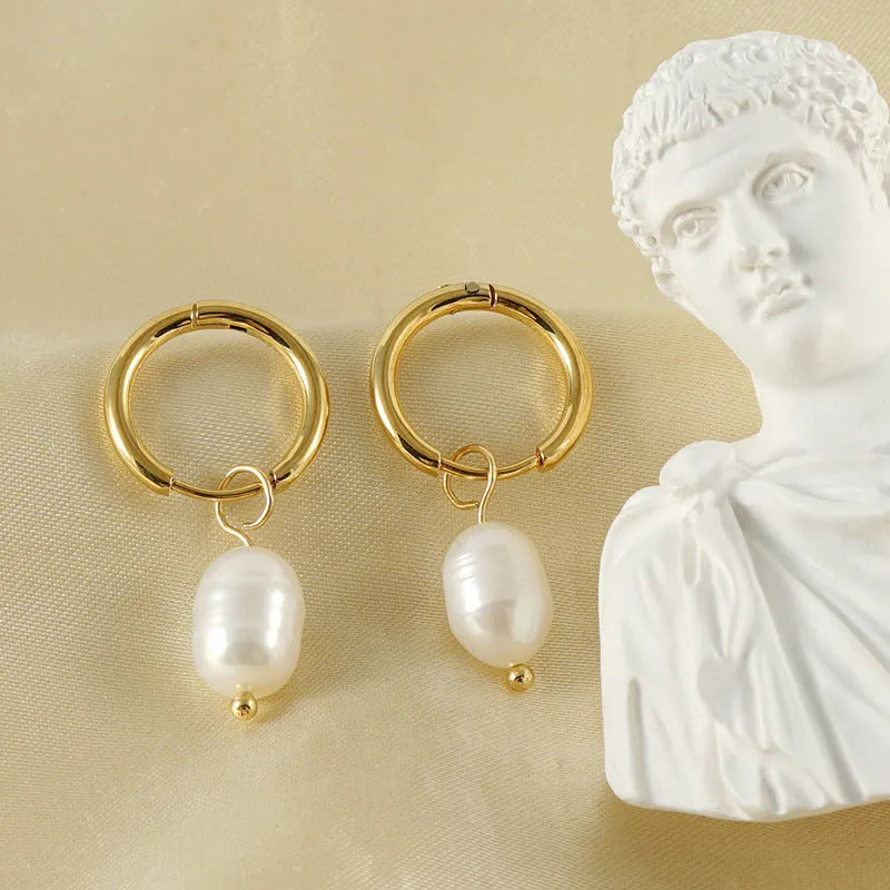 A pair of gold geometric earrings with a pearl detail on a stainless steel post.