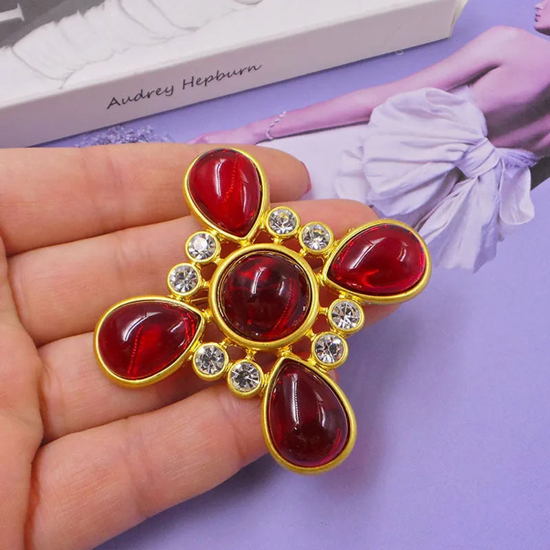 A vintage-style zinc alloy brooch with a baroque cross design and crystal accents.